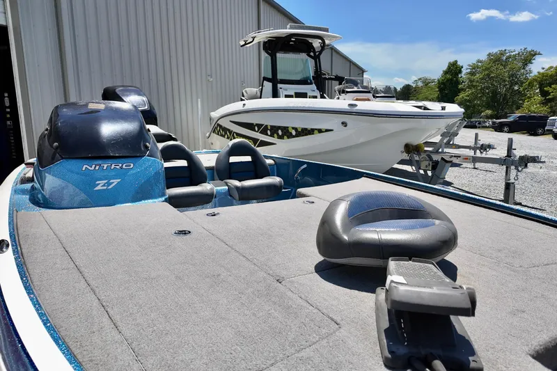 Slide: The Image of 2010 Nitro Z-7 boat with seating, parked near a white boat under clear skies. - 8