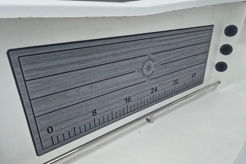 Slide: The Image of 2024 NauticStar 251 Hybrid boat ruler with compass design on deck. - 12