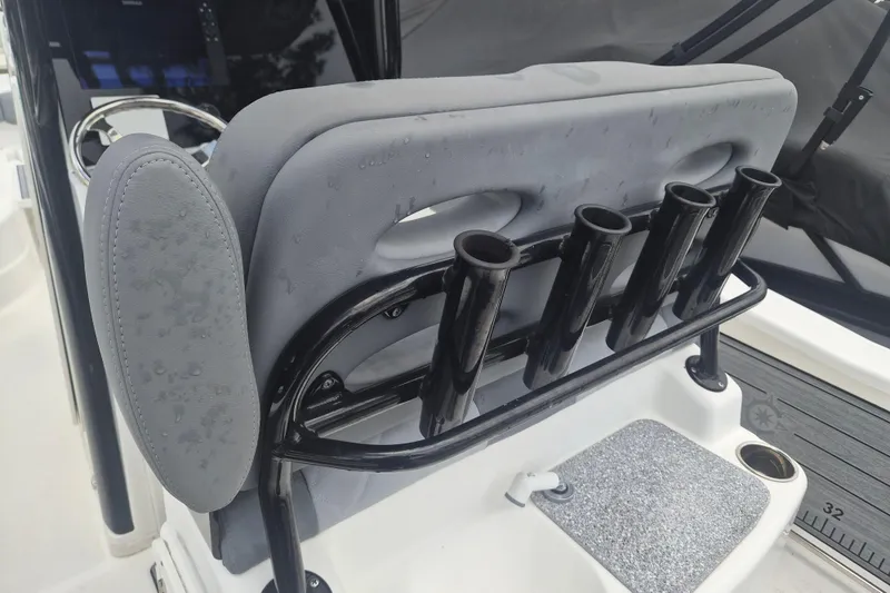 Slide: The Image of 2024 NauticStar 251 Hybrid boat seat with rod holders and wet surface. - 13
