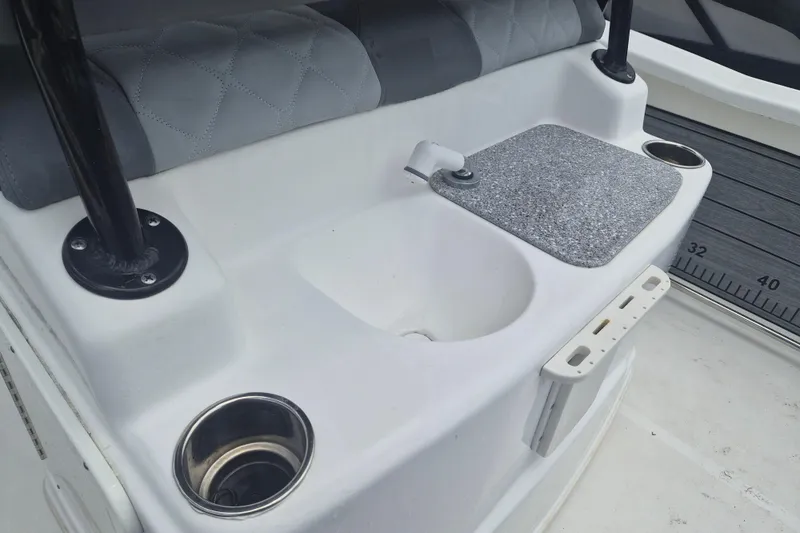 Slide: The Image of 2024 NauticStar 251 Hybrid boat interior with sink, cup holders, and seating. - 14