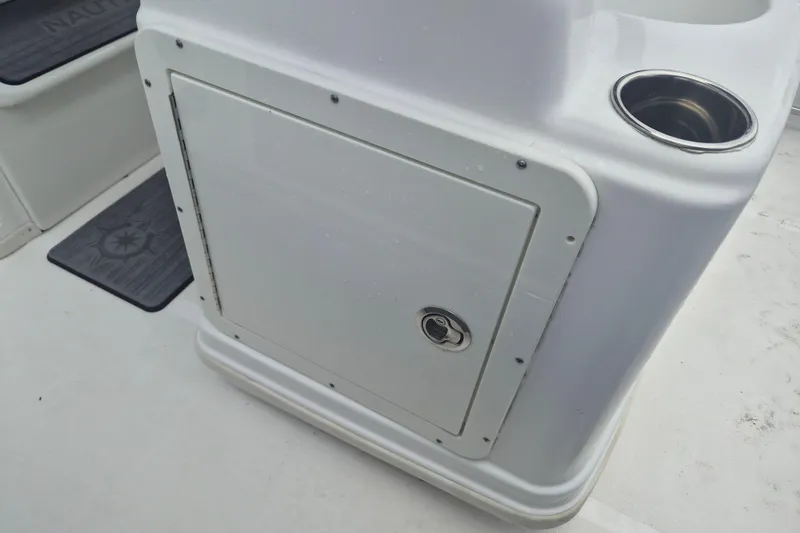 Slide: The Image of 2024 NauticStar 251 Hybrid boat console with storage compartment and cup holder. - 15