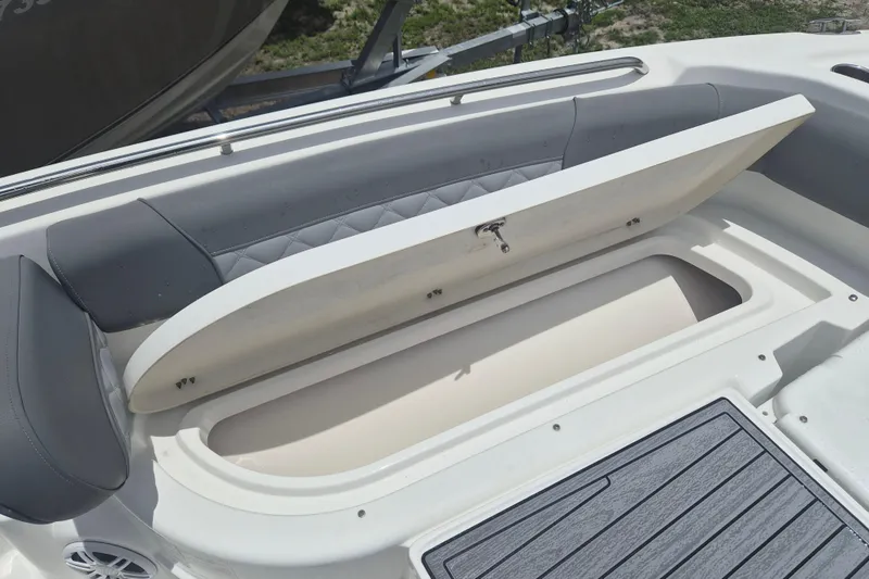Slide: The Image of 2024 NauticStar 251 Hybrid boat with open storage compartment and cushioned seating. - 29