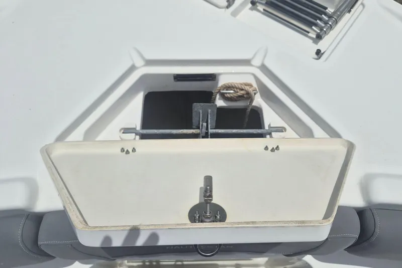 Slide: The Image of 2024 NauticStar 251 Hybrid boat anchor storage compartment with rope and hardware. - 33