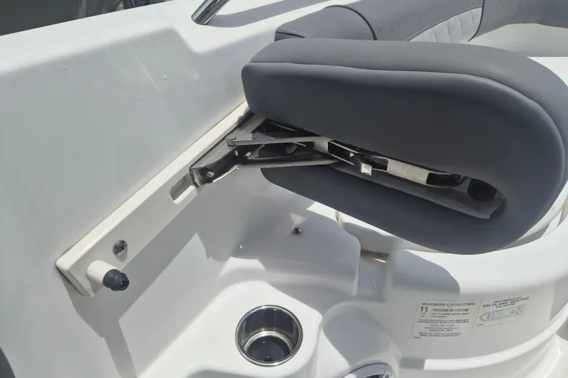 Slide: The Image of 2024 NauticStar 251 Hybrid boat seat detail with cup holder and capacity label. - 36