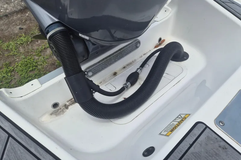 Slide: The Image of 2024 NauticStar 251 Hybrid boat engine compartment with hoses and caution label. - 40