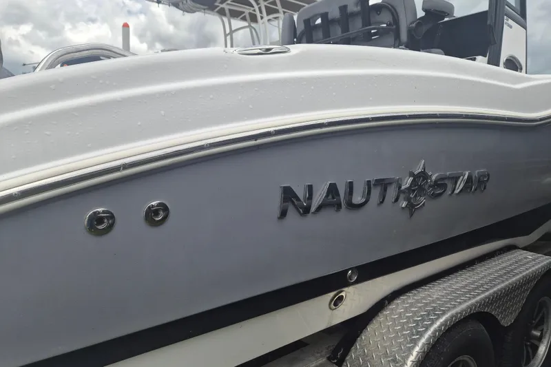 Slide: The Image of 2024 NauticStar 251 Hybrid boat side view with logo and trailer. - 5