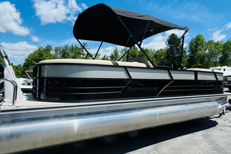 Slide: The Image of 2026 Berkshire 24 RFX CTS pontoon boat with canopy, parked outdoors under blue sky. - 4
