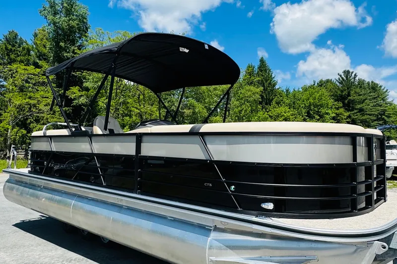 Slide: The Image of 2026 Berkshire 24 RFX CTS pontoon boat with canopy, parked outdoors under blue sky. - 6