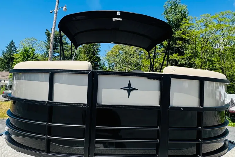 Slide: The Image of 2026 Berkshire 24 RFX CTS pontoon boat with canopy, parked outdoors on a sunny day. - 7