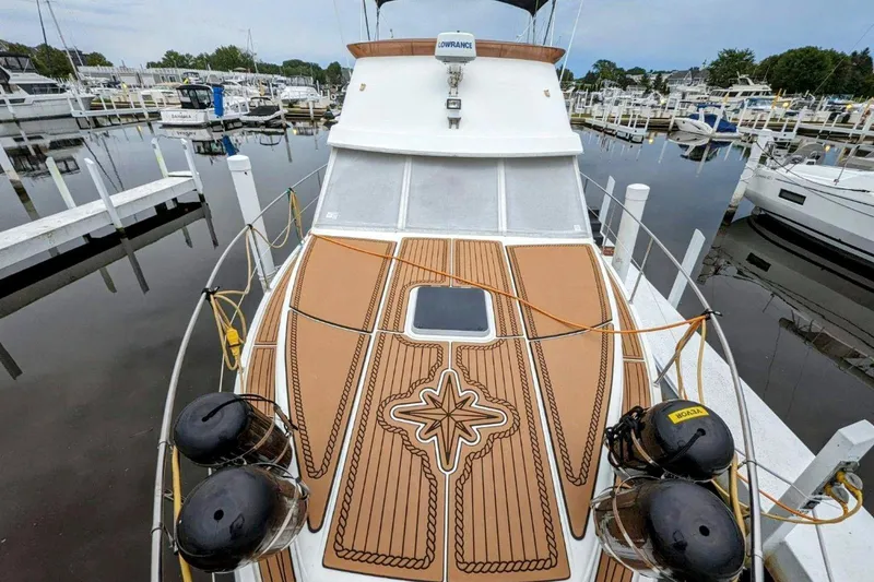 Slide: The Image of 1990 Prowler Aft Cabin boat docked at marina, featuring detailed deck design. - 8