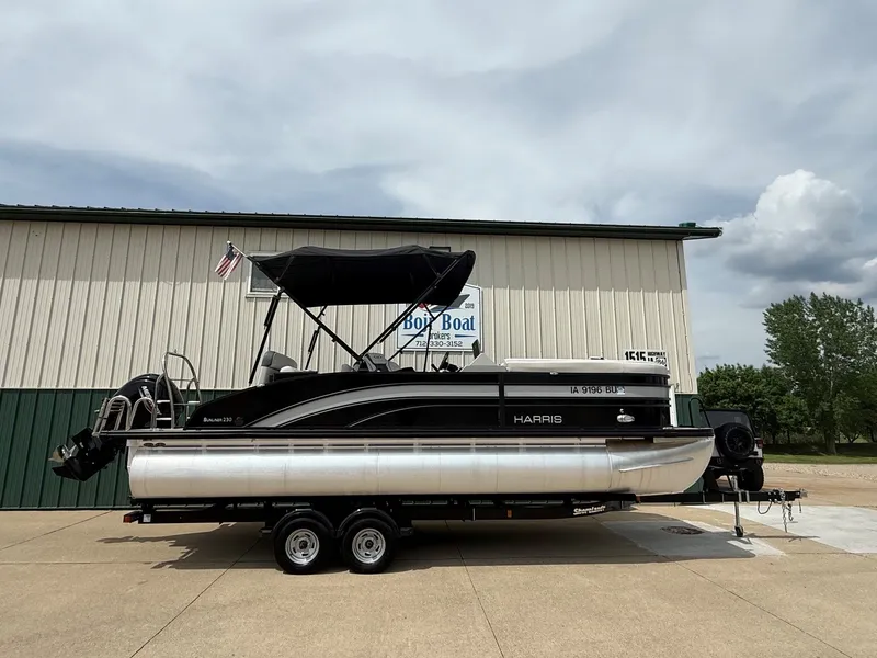 The Image of 2021 Harris Sunliner 230 pontoon boat on trailer in front of warehouse. - 0