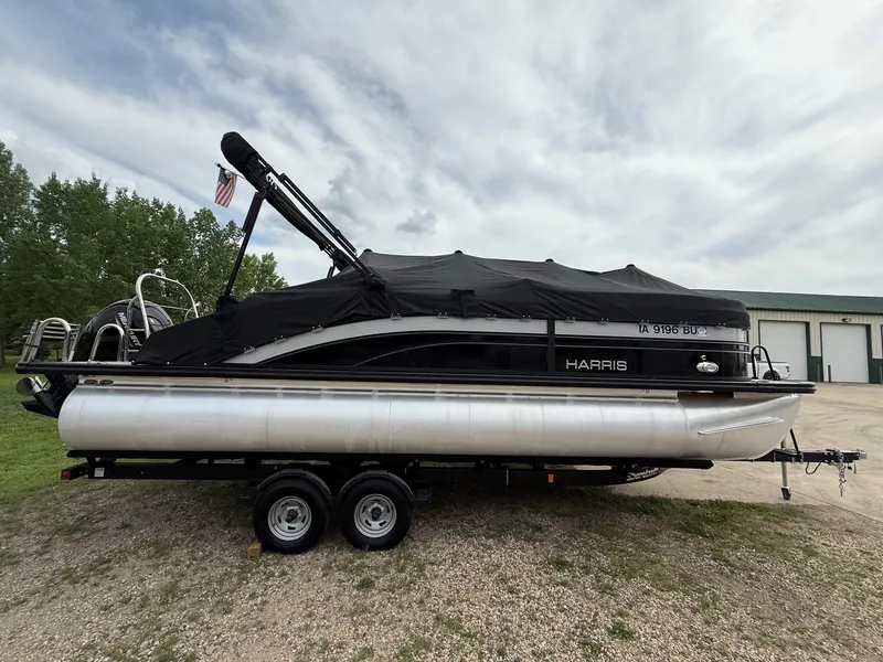 Slide: The Image of 2021 Harris Sunliner 230 pontoon boat on trailer, covered, parked outdoors. - 31