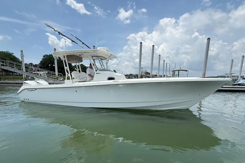 The Image of 2018 Edgewater 320CC boat docked on calm water under a partly cloudy sky. - 0