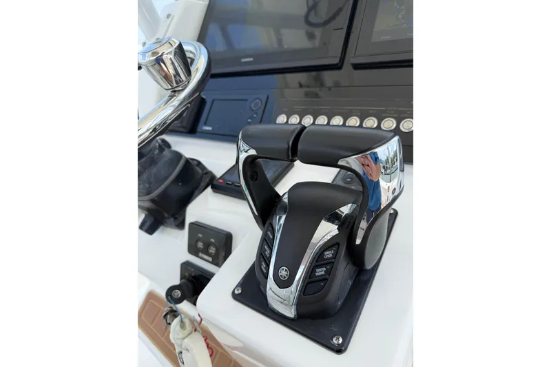 Slide: The Image of Control panel of a 2018 Edgewater 320CC boat with steering wheel and throttle. - 11