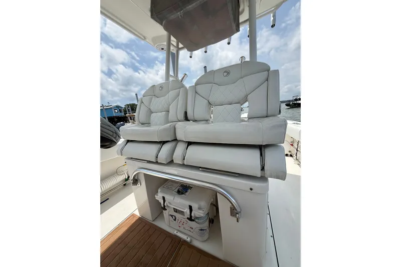 Slide: The Image of Luxurious seating on 2018 Edgewater 320CC boat, featuring white cushioned seats and storage below. - 12
