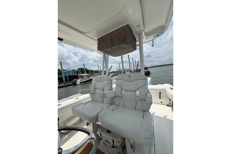 Slide: The Image of 2018 Edgewater 320CC boat interior with dual captain's chairs and steering wheel. - 13