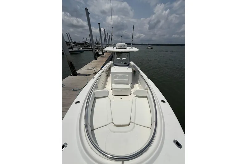 Slide: The Image of 2018 Edgewater 320CC boat docked, showcasing spacious seating and sleek design. - 15