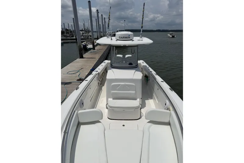 Slide: The Image of 2018 Edgewater 320CC boat docked, featuring spacious seating and Garmin equipment. - 16
