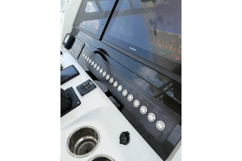 Slide: The Image of Edgewater 320CC 2018 boat dashboard with Garmin displays and control panel. - 17