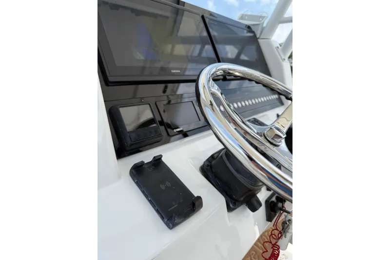 Slide: The Image of Steering console of 2018 Edgewater 320CC boat with modern navigation equipment. - 18