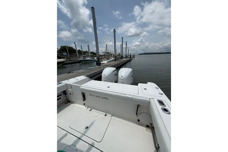 Slide: The Image of 2018 Edgewater 320CC boat docked at marina under cloudy sky. - 20