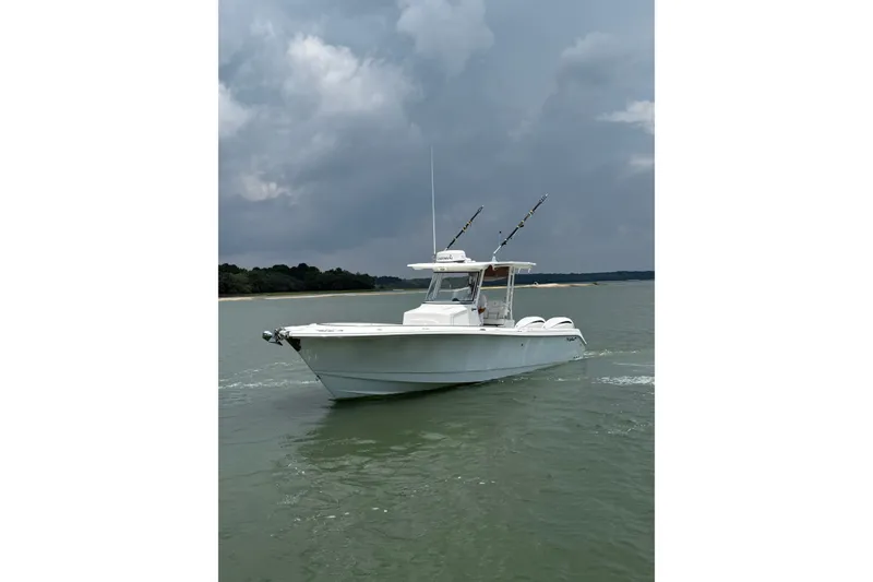 Slide: The Image of 2018 Edgewater 320CC boat on water under cloudy sky. - 3