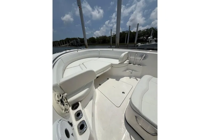 Slide: The Image of 2018 Edgewater 320CC boat interior with white seating and cup holders under a blue sky. - 8