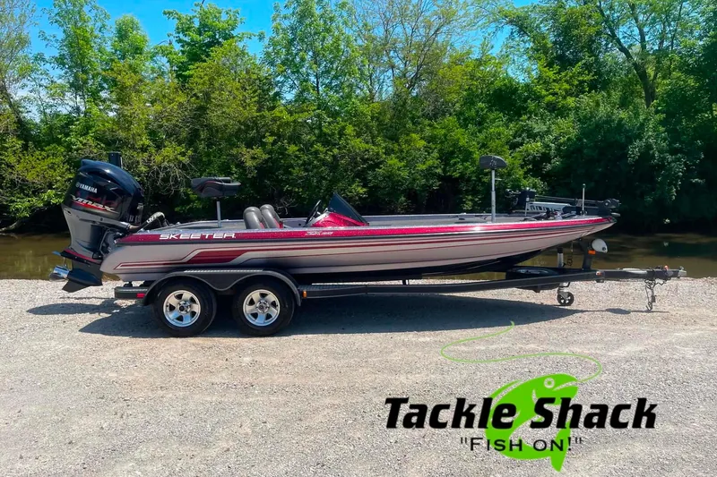 The Image of 2014 Skeeter ZX20 boat on trailer, parked near a river, with Tackle Shack logo. - 1