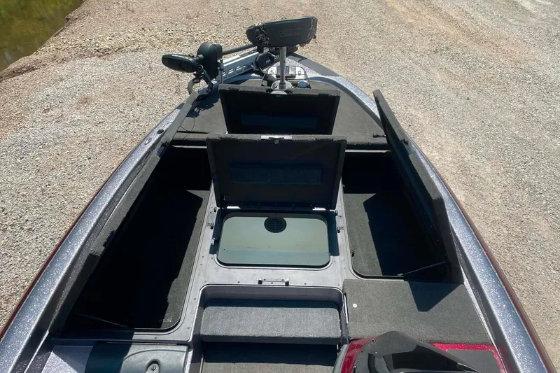 Slide: The Image of 2014 Skeeter ZX20 boat interior with open storage compartments on a gravel surface. - 10