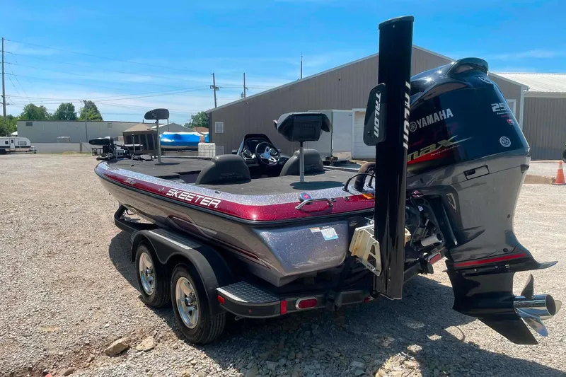 Slide: The Image of 2014 Skeeter ZX20 bass boat with Yamaha engine, parked on gravel lot. - 5