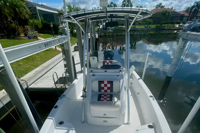 Slide: The Image of 2015 Glasstream 228 TE boat docked by a calm waterfront, featuring a checkered seat design. - 10