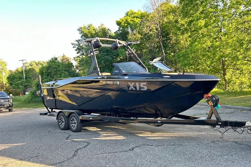 The Image of 2022 Axis T250 boat on trailer, parked on a sunny road with trees. - 0