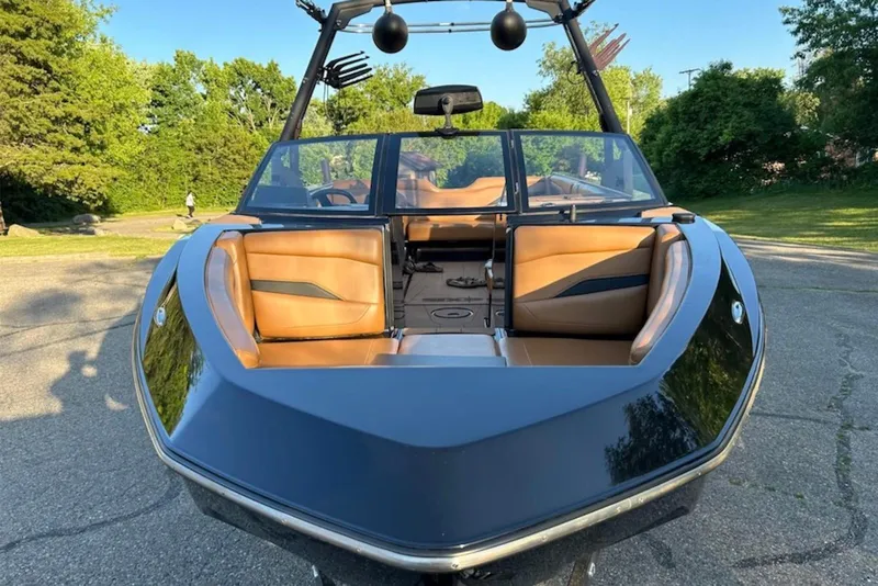 Slide: The Image of 2022 Axis T250 boat with tan interior, parked outdoors on a sunny day. - 2