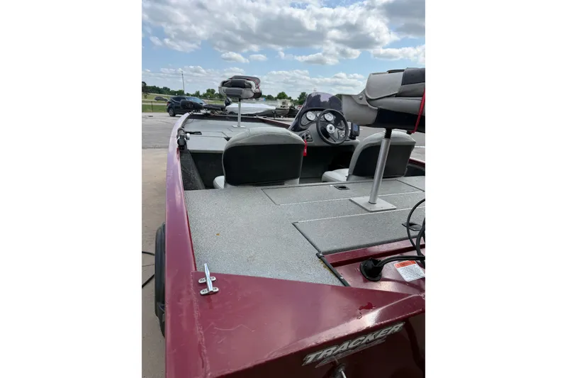 Slide: The Image of 2018 Tracker Pro 170 boat with seating and steering wheel, parked outdoors under cloudy sky. - 9