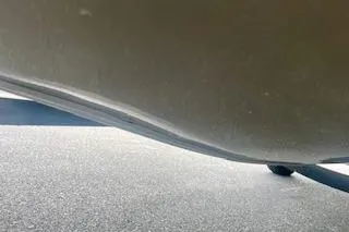 Slide: The Image of 2016 Tracker Pro Team 175 TXW boat hull with visible dent on pavement. - 10