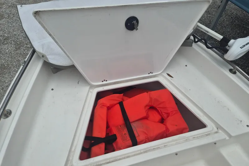 Slide: The Image of Open storage compartment on 2021 Key West 1720 Center Console boat with life jacket inside. - 19