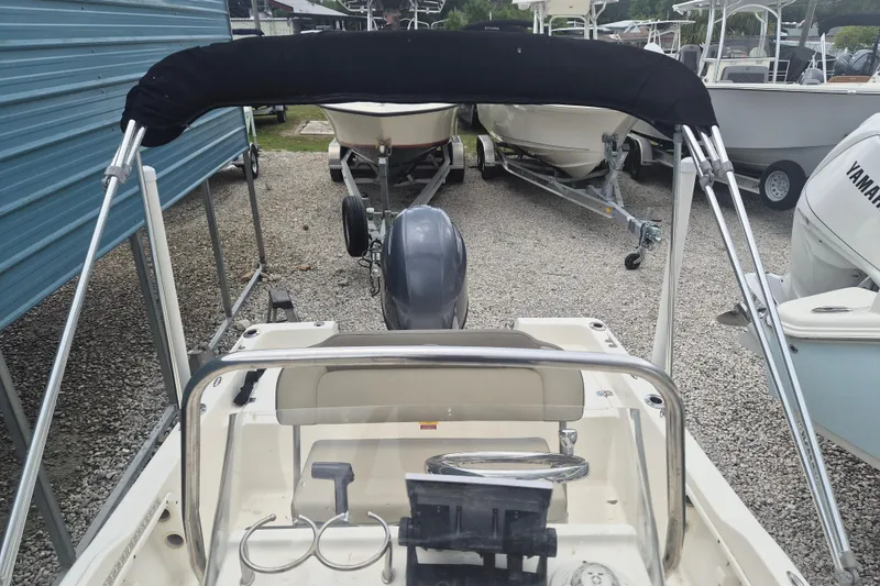 Slide: The Image of 2021 Key West 1720 Center Console boat with canopy, parked among other boats. - 20
