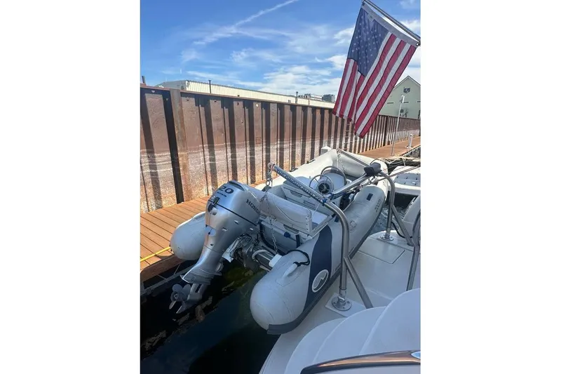 Slide: The Image of 2004 Sea Ray 390 Motor Yacht with dinghy and American flag at dock. - 19