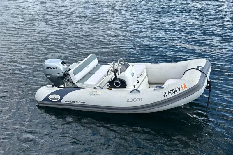 Slide: The Image of Walker Bay inflatable boat with Honda motor on calm water. - 20