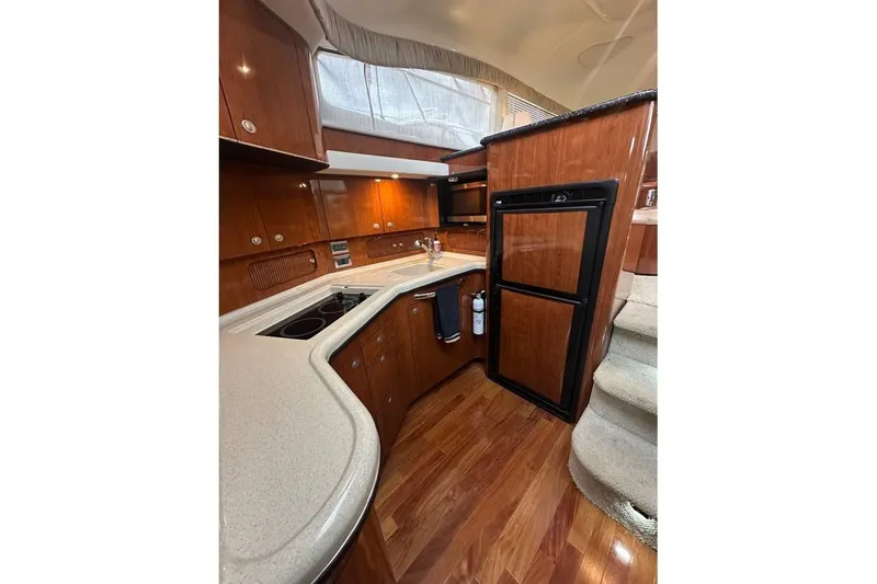 Slide: The Image of Luxurious 2004 Sea Ray 390 Motor Yacht kitchen with wood cabinetry and modern appliances. - 4