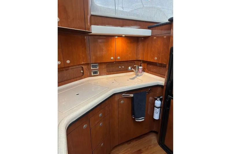 Slide: The Image of Luxurious 2004 Sea Ray 390 Motor Yacht kitchen with wood cabinetry and modern amenities. - 5