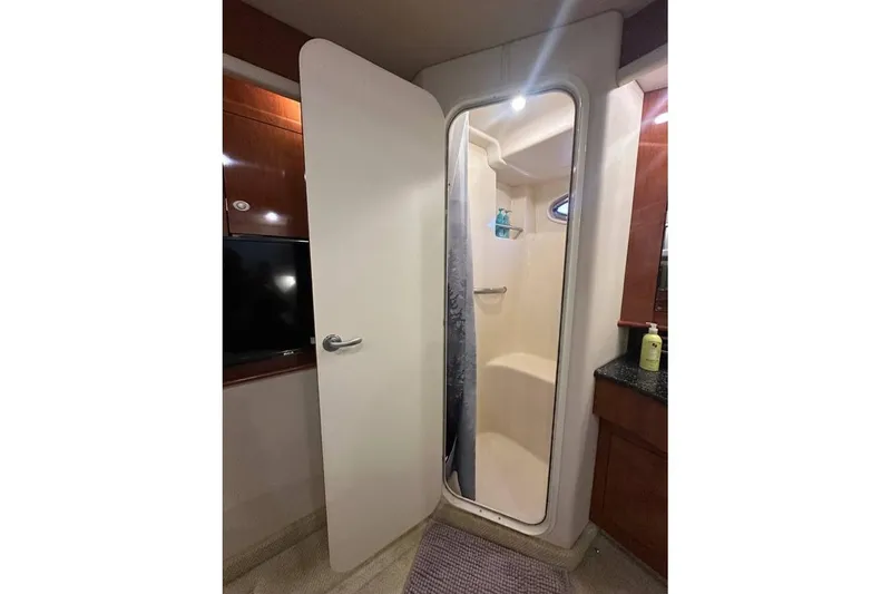 Slide: The Image of 2004 Sea Ray 390 Motor Yacht bathroom with shower, wooden cabinetry, and modern fixtures. - 8