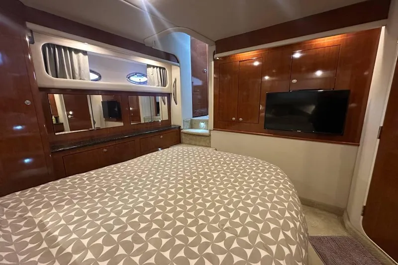 Slide: The Image of Luxurious 2004 Sea Ray 390 Motor Yacht bedroom with elegant wood cabinetry and modern TV. - 9