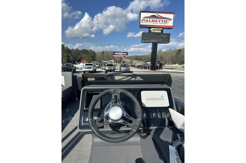 Slide: The Image of 2024 Manitou Cruise 22 Max Bench V-Toon dashboard with Garmin display, outdoor setting. - 12