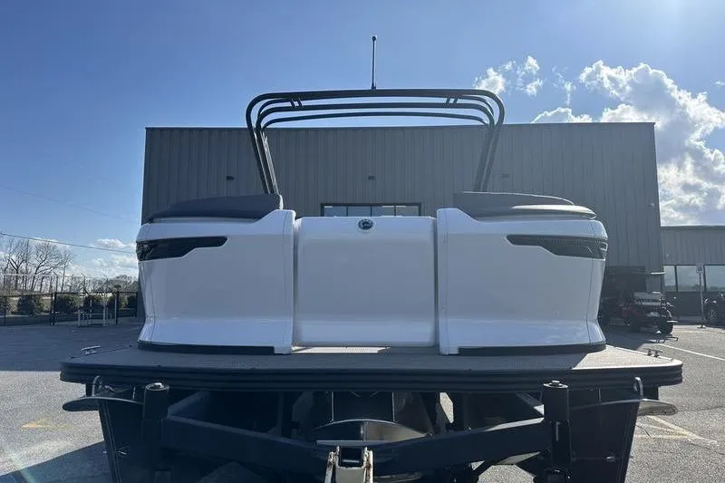 Slide: The Image of 2024 Manitou Cruise 22 Max Bench V-Toon boat on trailer, outdoor setting. - 3