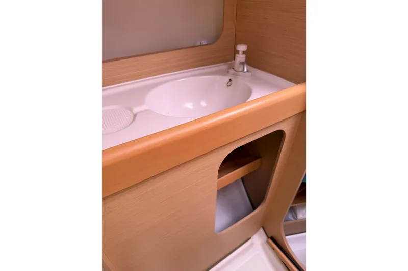 Slide: The Image of Interior sink area of 2014 Beneteau FIRST 25 S yacht, featuring wooden cabinetry. - 27