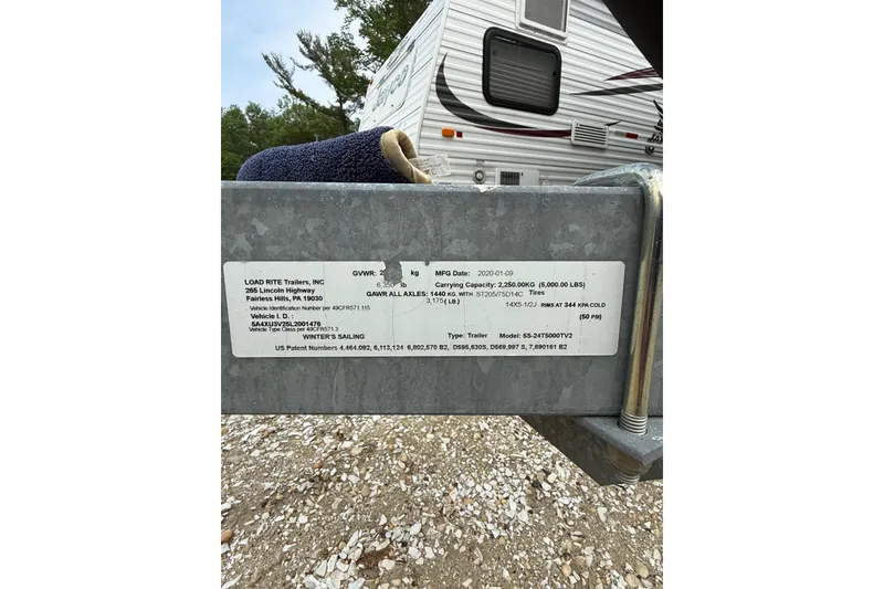 Slide: The Image of Trailer label with specifications, including GVWR and carrying capacity, near a Beneteau FIRST 25 S. - 38