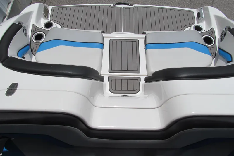 Slide: The Image of 2017 Yamaha Boats 242X E-Series interior with gray and blue seating, cup holders, and deck. - 12