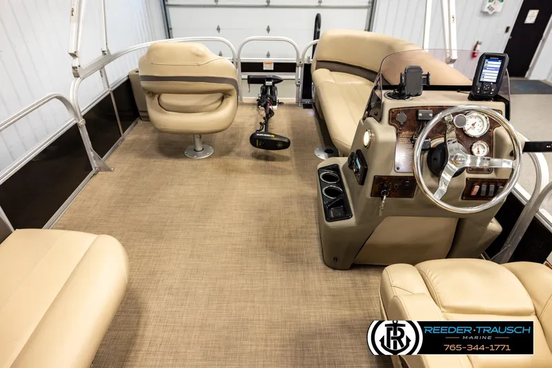 Slide: The Image of 2022 SUNTRACKER BASS BUGGY 18 DLX interior with beige seating and steering console. - 17