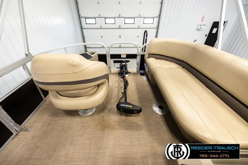 Slide: The Image of 2022 SUNTRACKER BASS BUGGY 18 DLX interior with beige seating and steering console. - 18